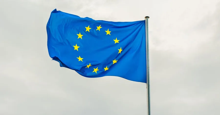The European Union flag gracefully waving on a flagpole against a cloudy sky in Strasbourg, France.