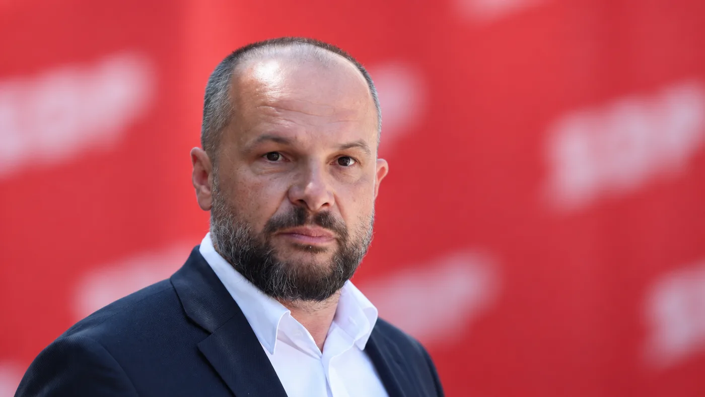 AI ilustracija Siniše Hajdaša Dončića ispred zamućene crvene političke pozadine